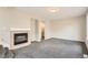 Open living room with a fireplace, neutral walls, carpet, and an open doorway at 10626 Cherrybrook Cir, Highlands Ranch, CO 80126