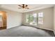 Main bedroom featuring natural light, tray ceiling with ceiling fan, and neutral decor at 10626 Cherrybrook Cir, Highlands Ranch, CO 80126