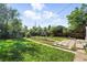 Lush backyard featuring garden beds, mature trees, and ample space for outdoor activities and relaxation at 4315 S Elati St, Englewood, CO 80110