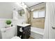 A well-lit bathroom with a shower-tub combination, and decorative tiles at 4315 S Elati St, Englewood, CO 80110