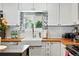 Modern kitchen featuring a farmhouse sink, white cabinets, butcher block counters, and subway tile backsplash at 4315 S Elati St, Englewood, CO 80110