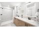 Stylish bathroom with double sinks, wood cabinets, modern fixtures, and walk-in shower at 1103 Spartan Ave, Berthoud, CO 80513