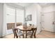 Bright dining area with wood table, modern chairs, and sliding glass door to the outside at 1103 Spartan Ave, Berthoud, CO 80513