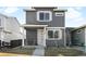 Charming two-story home featuring a covered front porch and modern gray siding, enhancing its curb appeal at 1103 Spartan Ave, Berthoud, CO 80513