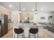 Beautiful kitchen with a large island and modern lighting fixtures that flows into the living area at 1103 Spartan Ave, Berthoud, CO 80513