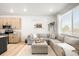 Comfortable living room adjacent to the kitchen featuring a large sectional sofa and lots of natural light at 1103 Spartan Ave, Berthoud, CO 80513