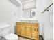 A bathroom featuring a wooden vanity with a granite countertop, an oval mirror, and a toilet at 641 E 104Th Pl, Northglenn, CO 80233