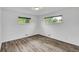 Corner bedroom featuring two windows, neutral paint, and wood-look flooring at 641 E 104Th Pl, Northglenn, CO 80233