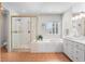 Bright bathroom featuring a separate shower and soaking tub, complete with neutral tile and vanity at 7425 S Utica St, Littleton, CO 80128