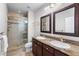 Bathroom featuring double sinks, granite counters and glass enclosed shower at 7425 S Utica St, Littleton, CO 80128