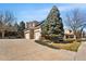 Charming home featuring a two-car garage, mature landscaping, and solar panels for energy efficiency at 7425 S Utica St, Littleton, CO 80128