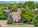 Charming two-story brick home with lush landscaping and mature trees, mountains in the background at 7425 S Utica St, Littleton, CO 80128