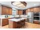 Modern kitchen featuring a gas cooktop, center island with seating, stainless steel appliances, and bright white countertops at 7425 S Utica St, Littleton, CO 80128