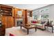 Cozy living room featuring built-in bookshelves, a fireplace, and plenty of natural light from the large windows at 7425 S Utica St, Littleton, CO 80128