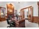Executive office with custom wood paneling, fireplace, and French doors leading to dining room at 7425 S Utica St, Littleton, CO 80128