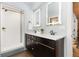 Modern bathroom with double vanity, illuminated mirrors, and walk-in shower at 3260 Curtis St, Denver, CO 80205