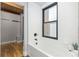 Clean bathroom with soaking tub, window, and subway tile at 3260 Curtis St, Denver, CO 80205