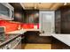 Modern kitchen with dark cabinets, stainless steel appliances, and wood floors at 3260 Curtis St, Denver, CO 80205