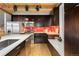 Modern kitchen with dark cabinets, stainless steel appliances and a white countertop at 3260 Curtis St, Denver, CO 80205