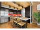 Sleek kitchen with dark wood cabinets, stainless steel appliances, and a red backsplash at 3260 Curtis St, Denver, CO 80205