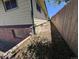 Side view of property highlighting the brick foundation, siding, and proximity to a wood fence at 327 S Pine St, Elizabeth, CO 80107