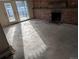 Bright living room featuring a brick fireplace and access to the outdoors through glass doors at 327 S Pine St, Elizabeth, CO 80107