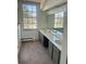 Bright bathroom featuring a double vanity with sinks, carpet flooring, and a large window offering natural light at 5449 S Locust St, Greenwood Village, CO 80111