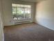 Bedroom with tan carpet, white walls, and a large window at 5449 S Locust St, Greenwood Village, CO 80111