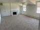 Spacious living room with carpet, a cozy fireplace, and ample natural light from the windows at 5449 S Locust St, Greenwood Village, CO 80111