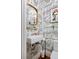 Chic powder room featuring whimsical wallpaper, a decorative mirror, and modern fixtures at 747 N Downing St, Denver, CO 80218