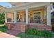 Inviting front porch features classic rocking chairs, a brick base, and elegant white columns, creating a relaxing outdoor space at 747 N Downing St, Denver, CO 80218