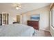 Comfortable bedroom with a large window, ceiling fan, and a modern TV atop a dresser at 7474 E Arkansas Ave # 13-02, Denver, CO 80231