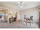This bedroom includes neutral carpet, a desk, and a ceiling fan with a nearby bathroom at 7474 E Arkansas Ave # 13-02, Denver, CO 80231