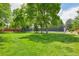 Expansive green common area featuring mature trees and a tennis court at 7474 E Arkansas Ave # 13-02, Denver, CO 80231