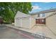 Attached two-car garage with beige siding provides convenient parking and storage for the townhome at 7474 E Arkansas Ave # 13-02, Denver, CO 80231