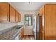 This kitchen features stainless steel appliances, wooden cabinets, and a view to the exterior at 7474 E Arkansas Ave # 13-02, Denver, CO 80231