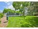 Exterior image of well-maintained community tennis court surrounded by lush green lawn and shade trees at 7474 E Arkansas Ave # 13-02, Denver, CO 80231
