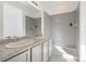 Modern bathroom with dual sinks, granite countertops, tiled shower, and gray tile accents at 23527 E 5Th Pl, Aurora, CO 80018