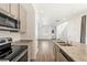 Modern kitchen with stainless steel appliances, granite countertops and hardwood floors overlooking a bright living area at 23527 E 5Th Pl, Aurora, CO 80018