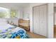 bedroom offering a view to a wooden crib, shuttered windows, and wooden closet doors at 4567 Grove St, Denver, CO 80211