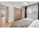 Charming bedroom boasts a comfortable bed, wooden closet doors and shuttered windows at 4567 Grove St, Denver, CO 80211