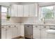 Bright, updated kitchen featuring sleek stainless steel appliances, white cabinetry, and modern fixtures at 4567 Grove St, Denver, CO 80211