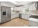 Spacious kitchen with stainless steel appliances, white cabinets, and plenty of natural light at 4567 Grove St, Denver, CO 80211