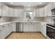 Bright kitchen with white cabinetry, stainless steel appliances, and a window view at 4567 Grove St, Denver, CO 80211