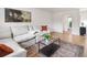 Bright living room boasts a cozy sectional sofa, modern coffee table, and open doorway at 4567 Grove St, Denver, CO 80211