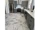 A full kitchen view of the gray cabinetry, new appliances, white countertops and striking marble floor at 69 W Cedar Ave, Denver, CO 80223