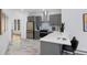 Kitchen and island with stainless steel appliances, gray cabinets and marble floors at 69 W Cedar Ave, Denver, CO 80223