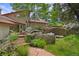 Charming front yard with stone pathway, mature trees, and rock features at 2398 Bitterroot Ln, Golden, CO 80401