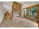 Open-concept living room with a stone fireplace, light wood floors, and a view of the backyard at 2398 Bitterroot Ln, Golden, CO 80401