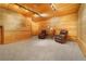 Cozy living room with wood paneling, comfortable armchairs, and soft lighting at 2398 Bitterroot Ln, Golden, CO 80401